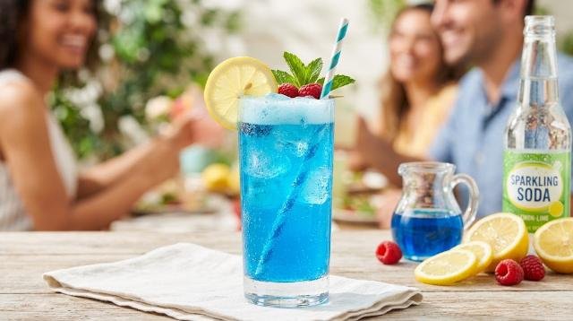 Blue Raspberry Lemonade Soda drink in a glass with fresh lemons and mint